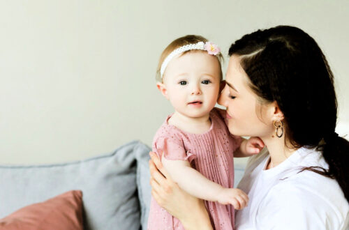 Brunette woman snuggling one year old - Social Media Image